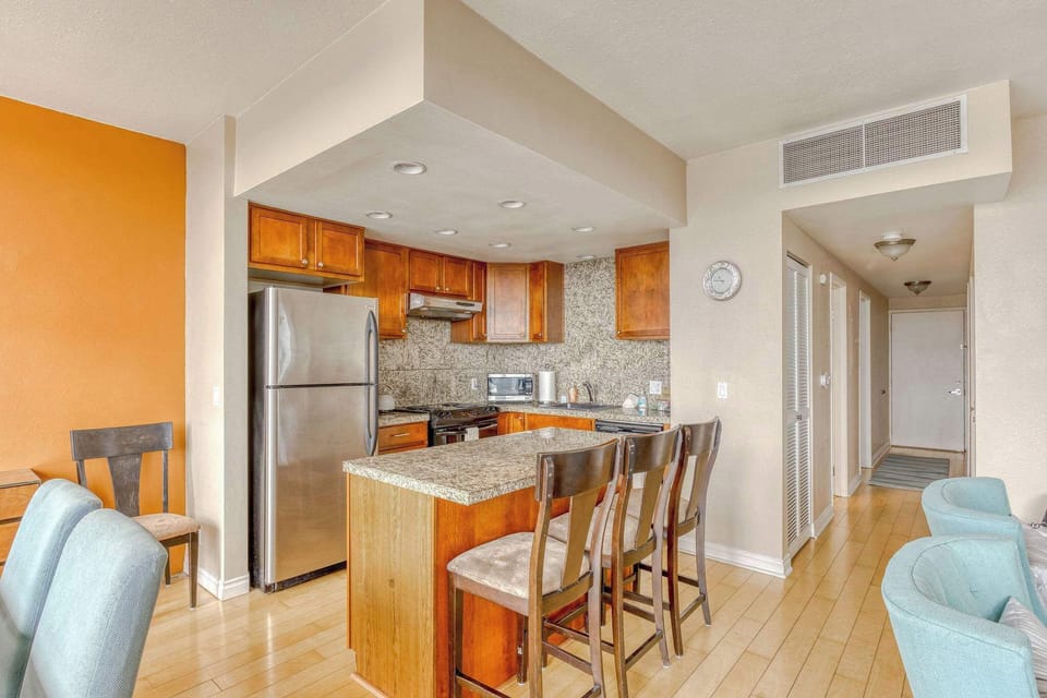 Cook and socialize with ease! This bright kitchen offers comfortable bar seating, modern appliances, and a seamless flow to the dining/living area for easy meals.