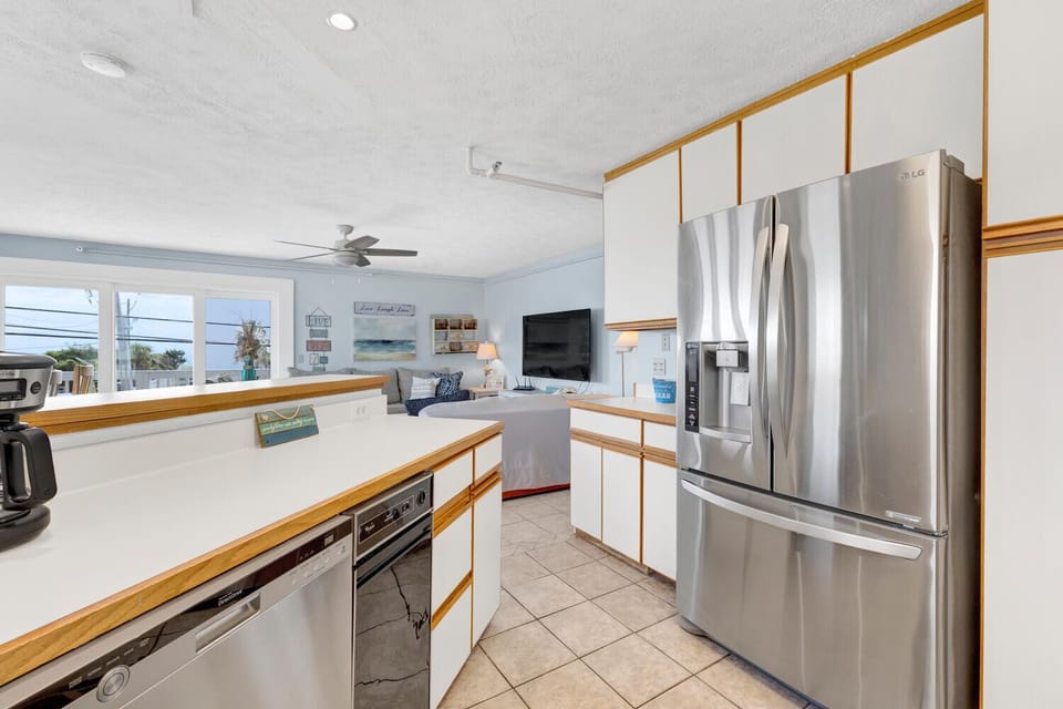 Your beachy kitchen features modern stainless appliances and breezy ocean views through the windows—perfect for morning coffee or prepping meals in style.