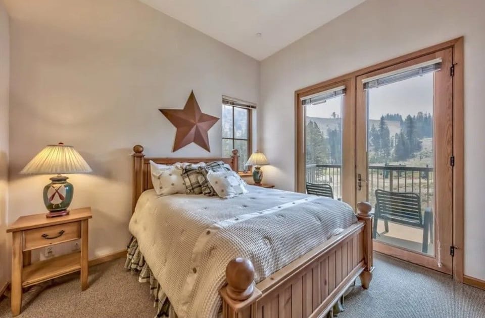 Wake up to beautiful views in this charming bedroom featuring a cozy queen bed, warm decor, and large windows that let in plenty of natural light.