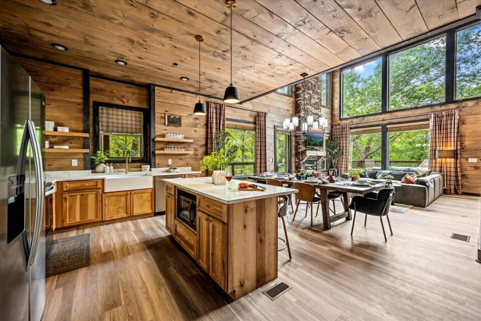 The view from just inside the front door of the cabin includes the kitchen, dining area, and living room.