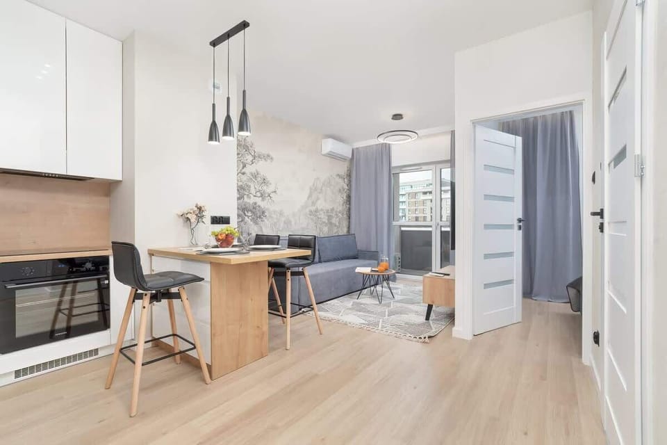 A bright hallway leading to the kitchen and living room. Light wood flooring gives a warm and inviting feel.
