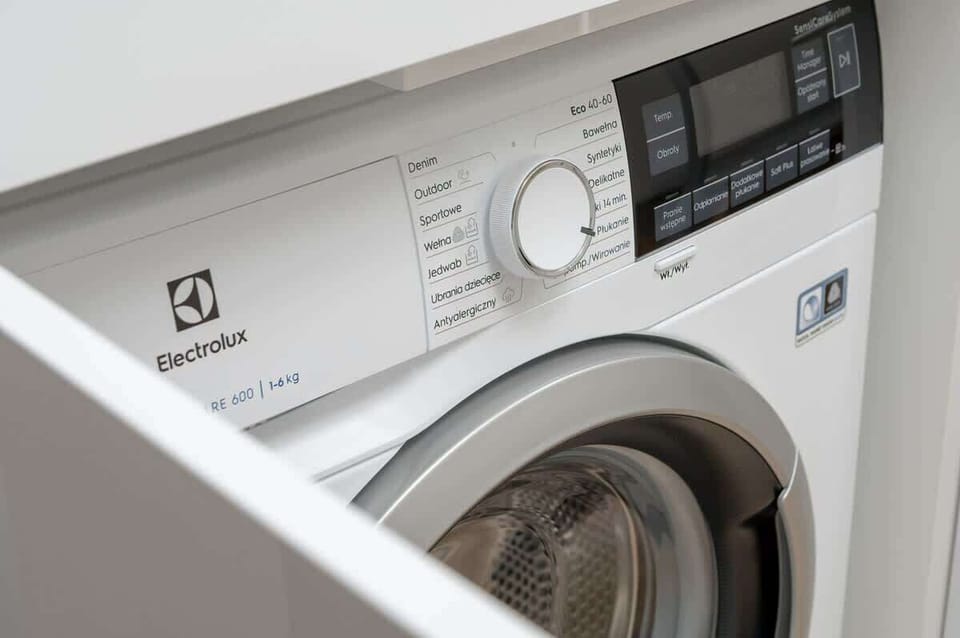 A washing machine in a laundry area, ready for use. The appliance is sleek and modern.