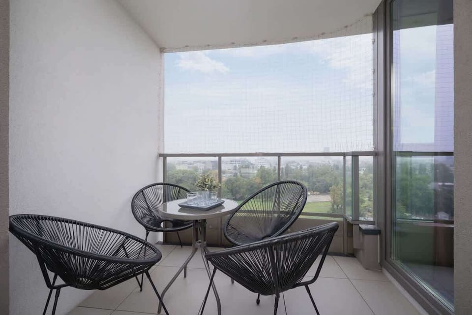 Balcony with two chairs and a round table, offering a peaceful view.