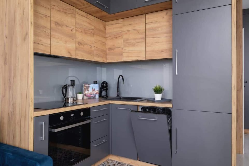 Modern kitchen with dark cabinets, built-in oven, and wood-textured finishes.