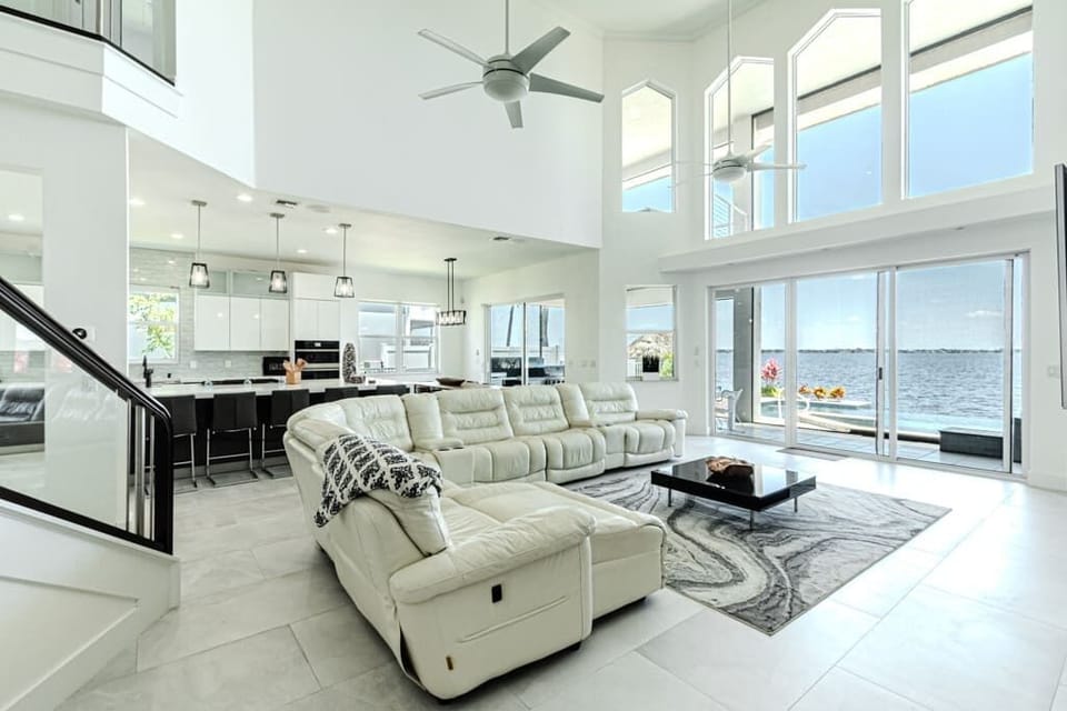 This breathing living room offers spectacular views of the waterfront with floor-to-ceiling windows and 20 ft ceilings, plus a spacious and luxurious open-concept layout.
