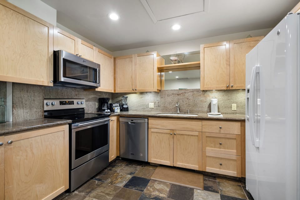 Your fully equipped kitchen awaits with modern appliances and granite counters, ready for preparing your favorite meals or morning coffee during your stay.