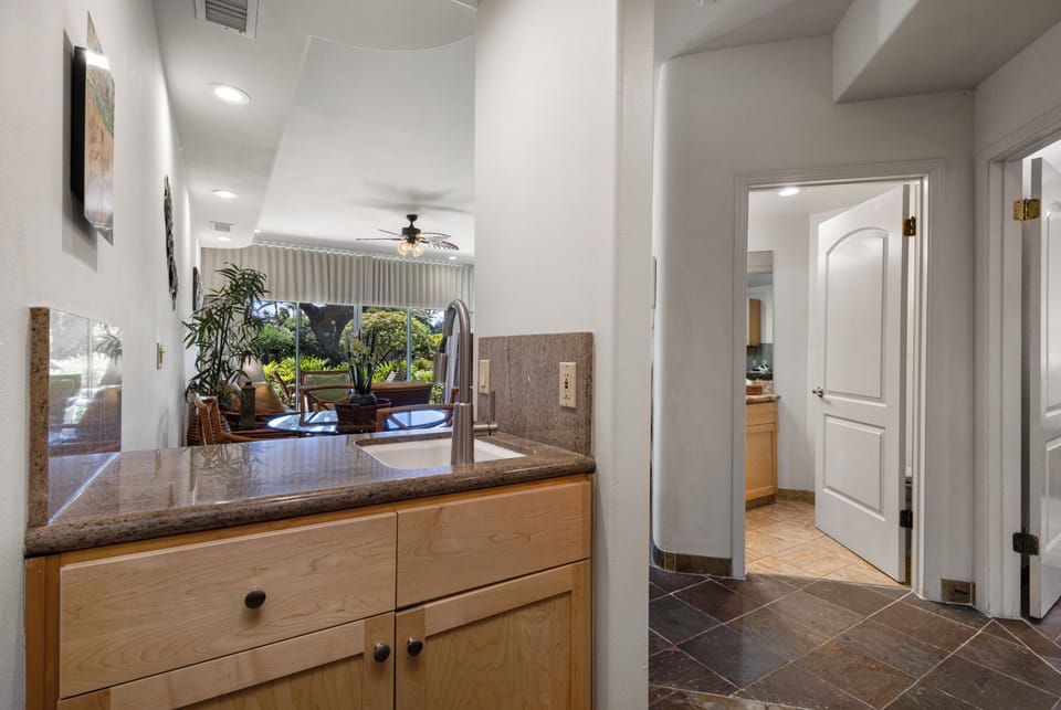 Bright, open kitchen flows effortlessly into the sunny living area, giving you a welcoming space to cook and unwind while enjoying lush garden views through the large windows.