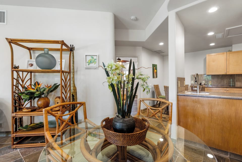 Your open-concept living space welcomes you with warm wood tones, tropical accents, and natural light flowing through modern architecture, creating a relaxing island-inspired retreat.