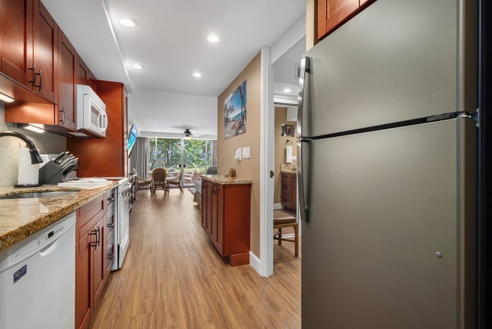 Your fully equipped kitchen features granite counters, warm wood cabinets, and stainless appliances—all the essentials for preparing meals at home. Open, bright, and leading to your dining and relaxation spaces.