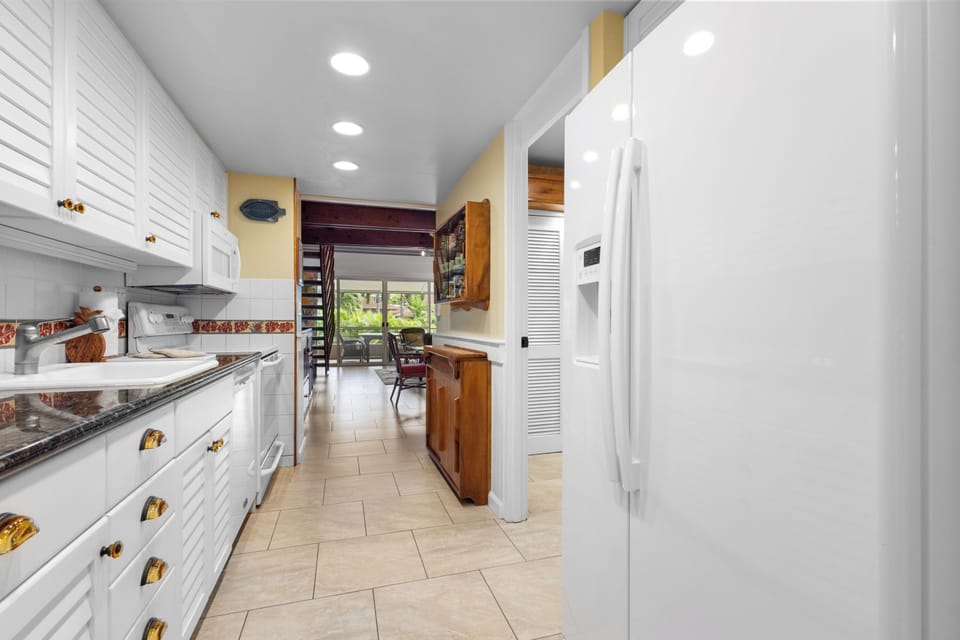 Your fully equipped kitchen features ample counter space, modern appliances, and bright recessed lighting—perfect for preparing meals and gathering with loved ones during your stay.