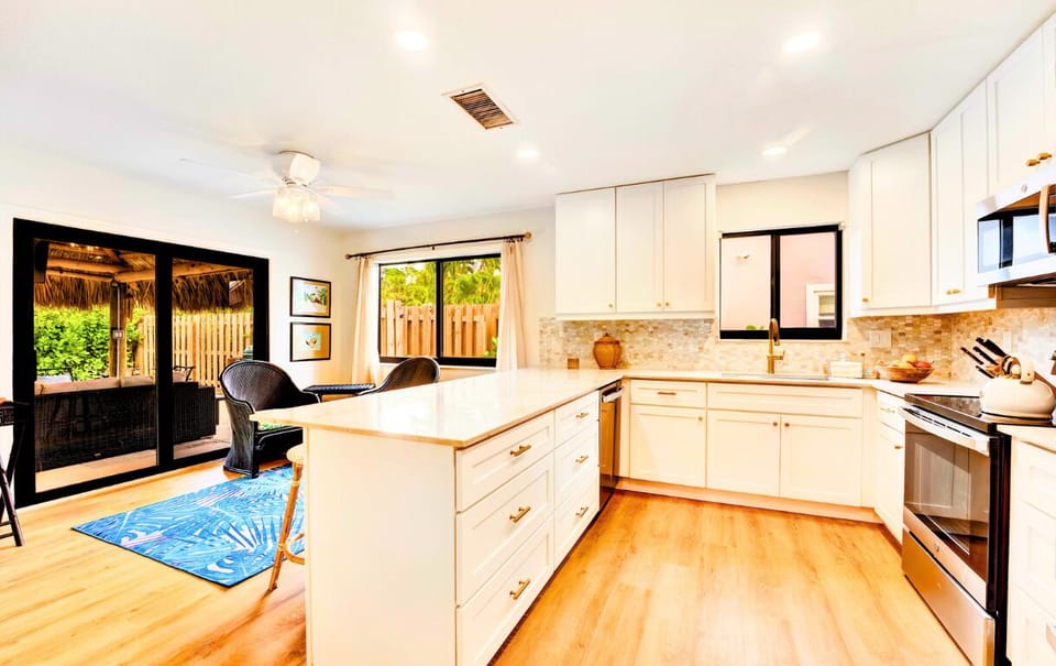 Coffee in a chic kitchen! White countertops, warm wood floors.