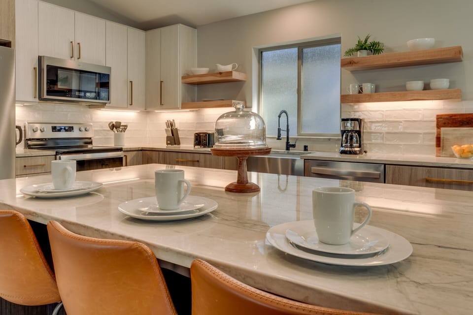 - Modern kitchen island with seating for three  
- Sleek countertops and stainless steel appliances  
- Fully stocked for family cooking and cozy meals