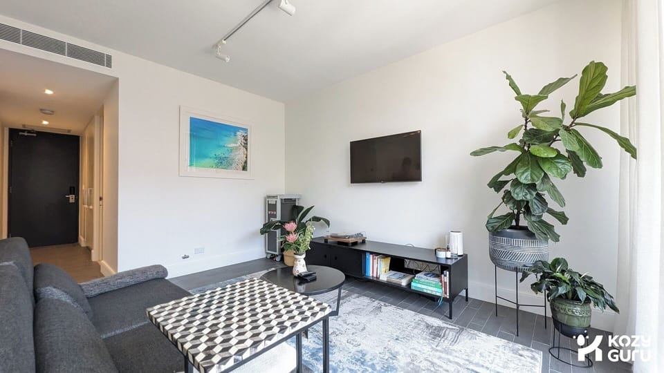 A chic, contemporary lounge featuring vibrant greenery and stylish wall art.