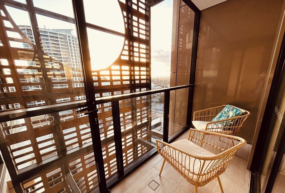 An inviting balcony area with patterned railings and wicker chairs.