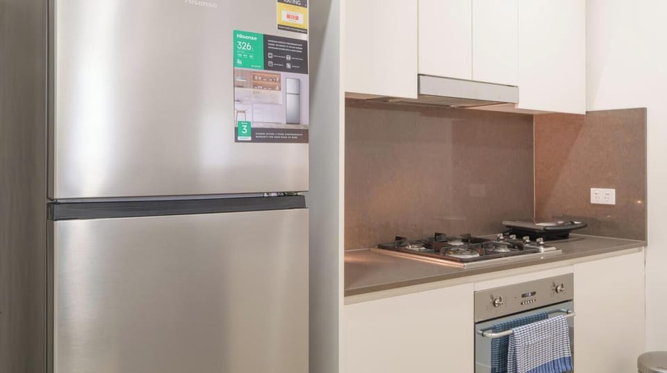 A close-up view of a sleek, stainless steel refrigerator paired with a modern stovetop 
