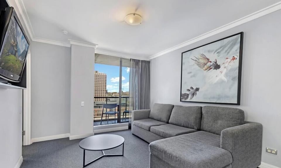 featuring a round coffee table and large floor-to-ceiling glass doors opening onto the balcony.