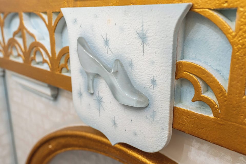 Discover a charming artistic detail that enhances your experience. The delicate gray shoe motif against a soft blue background with bold gold accents creates an inviting focal point, drawing you in to explore further.