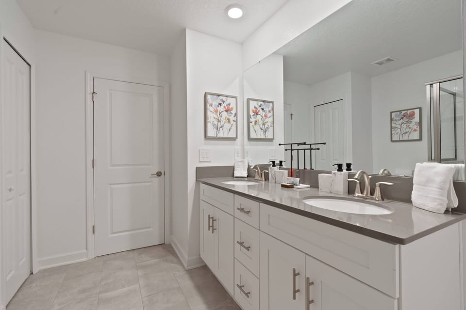 This bright bathroom offers a stylish double vanity with plenty of counter space for your travel essentials. Charming floral art and a clean, neutral palette create a refreshing atmosphere for your stay.