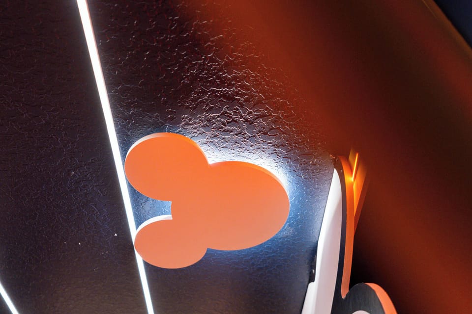 Enjoy a playful atmosphere with vibrant orange decor and a whimsical Mickey Mouse silhouette, enhanced by sleek modern lighting. This unique design brings a fun, lively energy to your stay, making it truly memorable.