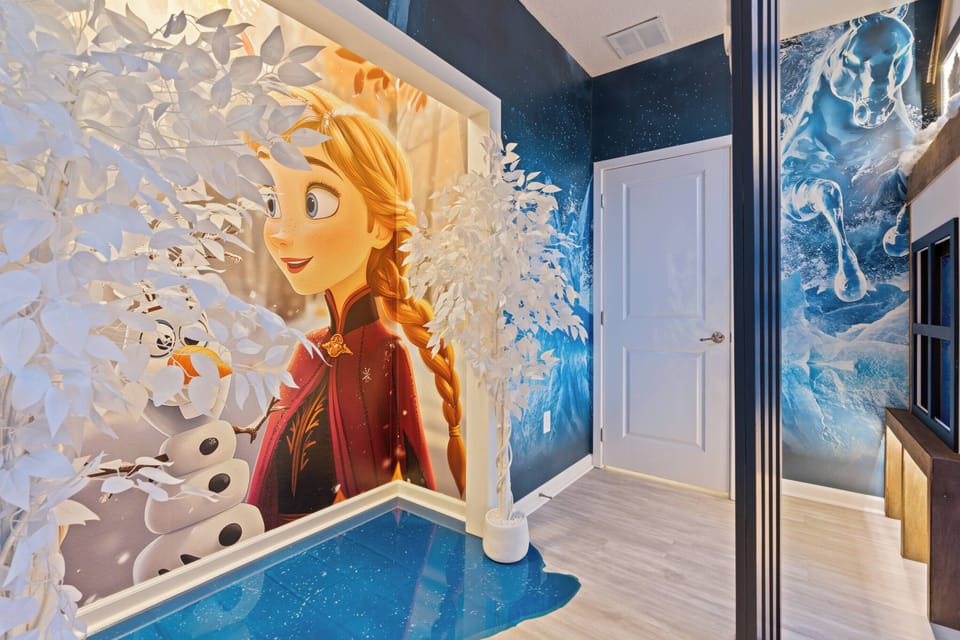 Immerse yourself in a whimsical atmosphere filled with vibrant murals of beloved characters, where icy blue hues complement crisp white decor. Discover a playful nook, ideal for kids or a memorable vacation photo backdrop.