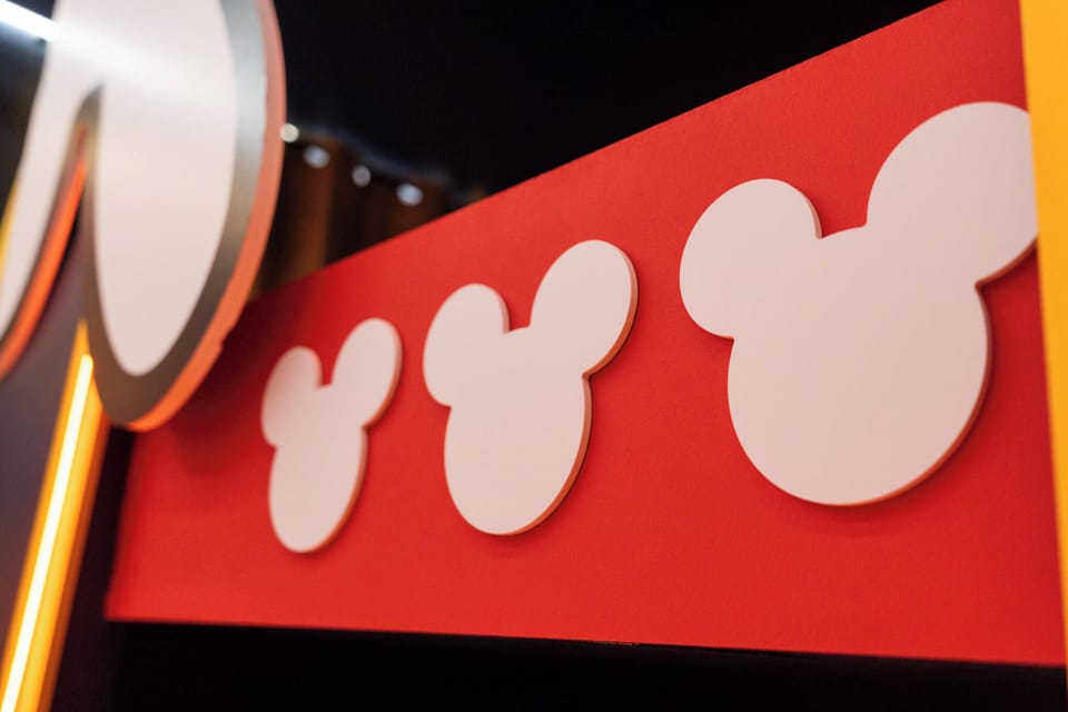 Experience a vibrant space with playful Mickey Mouse silhouettes on a bold red backdrop, creating a fun and nostalgic atmosphere. Perfect for families, the whimsical decor adds excitement to your stay, making it truly memorable.
