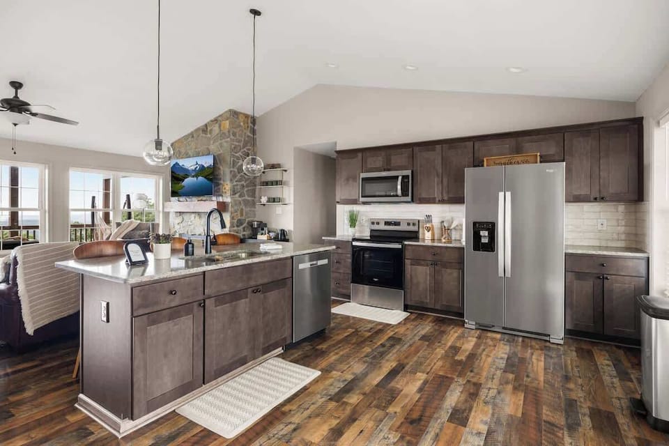 Bright open kitchen with stainless appliances and mountain-view windows