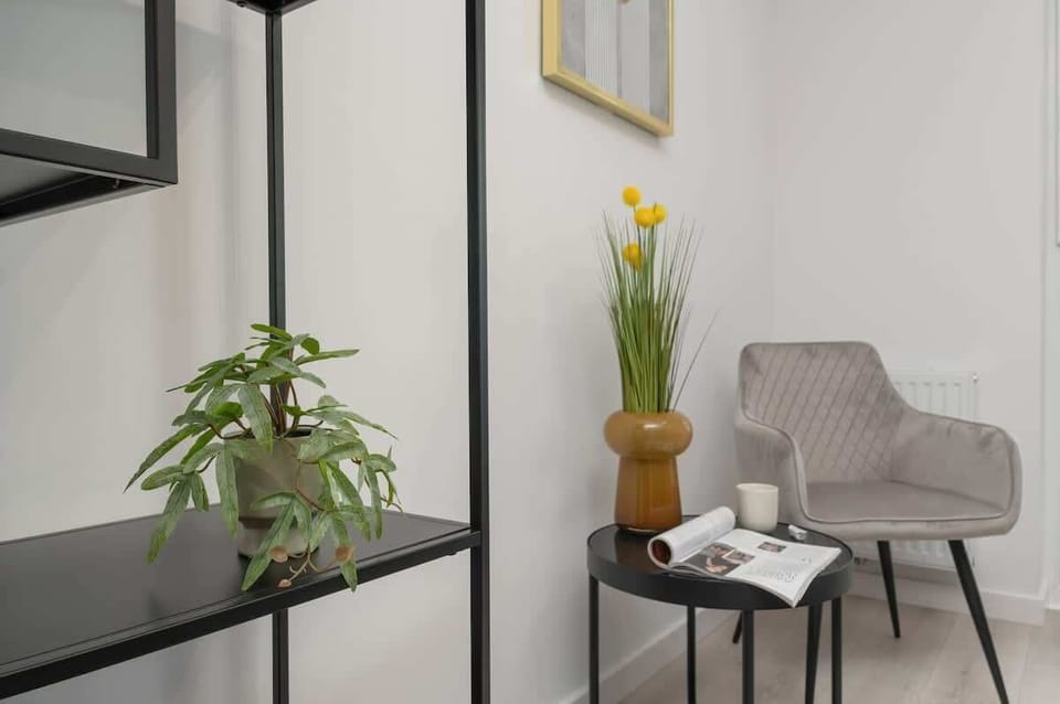 A quiet corner with a soft armchair, indoor plants, and tasteful wall art — ideal for reading or relaxing.