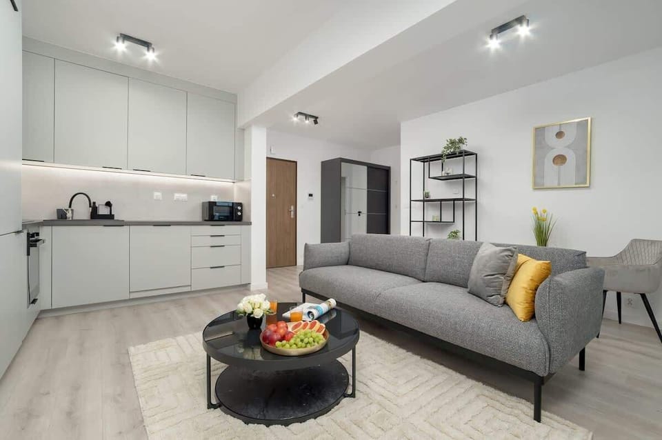 A modern, airy living space with soft grey furnishings and tasteful decor, perfect for relaxing or entertaining guests.