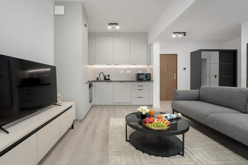 An open-plan layout combining a comfortable lounge area and a kitchen in a chic, contemporary design.