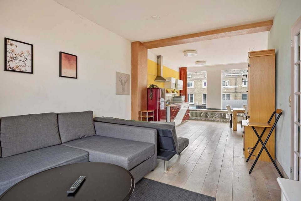 Open-plan living area with a modern kitchen and natural light from large windows