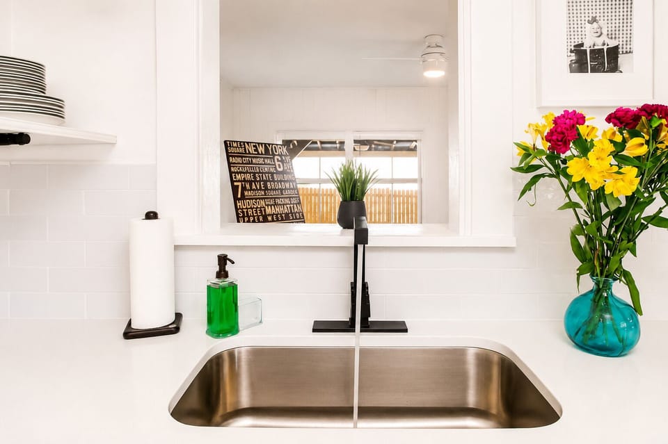 Bright modern kitchen sink area with stylish finishes and fresh floral touches