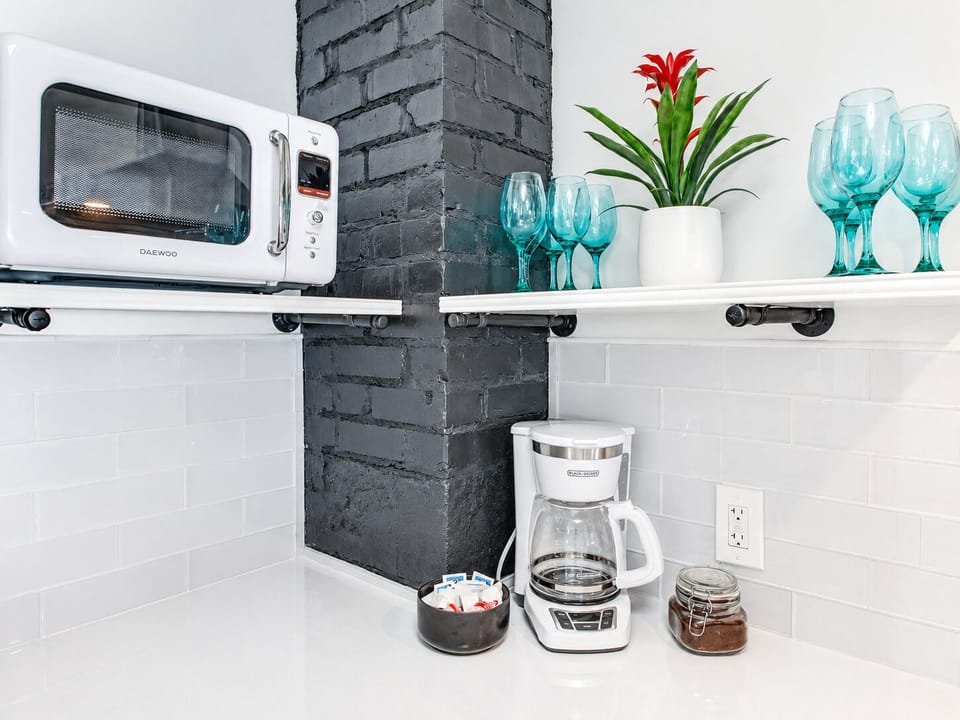 Bright coffee nook with microwave, glassware, and modern style