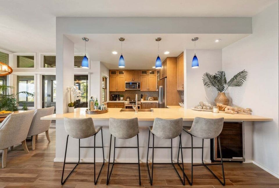 Kitchen counter with bar seating, pendant lighting, and open views into the living and dining areas for easy entertaining.