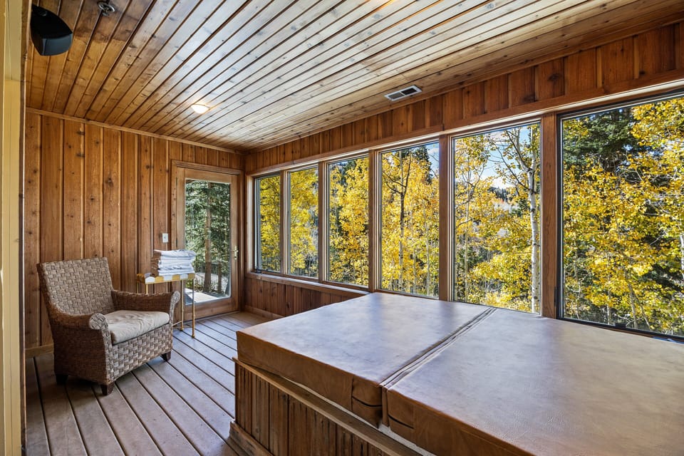 Relax and unwind in the enclosed deck area featuring a private hot tub and serene forest views. The perfect retreat for enjoying peaceful mountain mornings or starlit evenings.