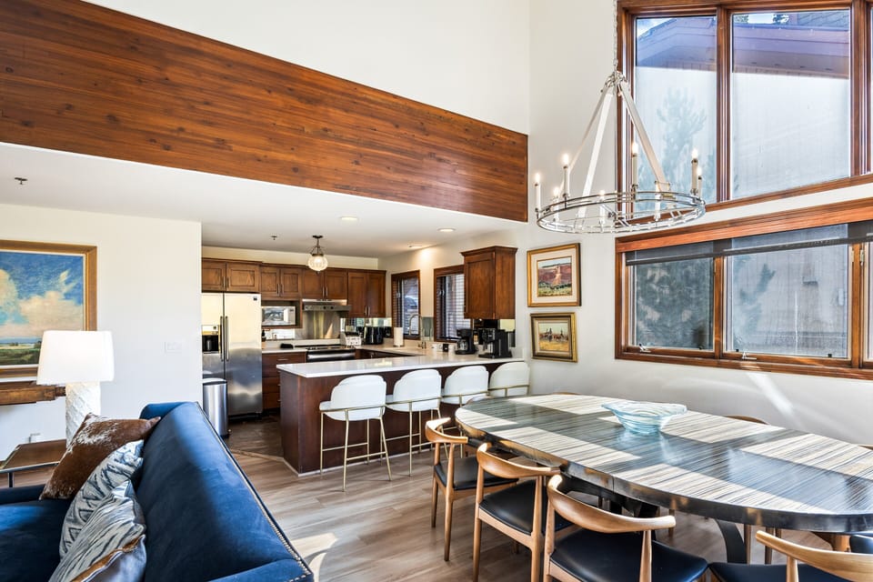 Stylish open-concept layout connecting the kitchen, dining, and living spaces. Large windows fill the room with natural light, while the spacious dining table is ideal for family meals or entertaining guests.