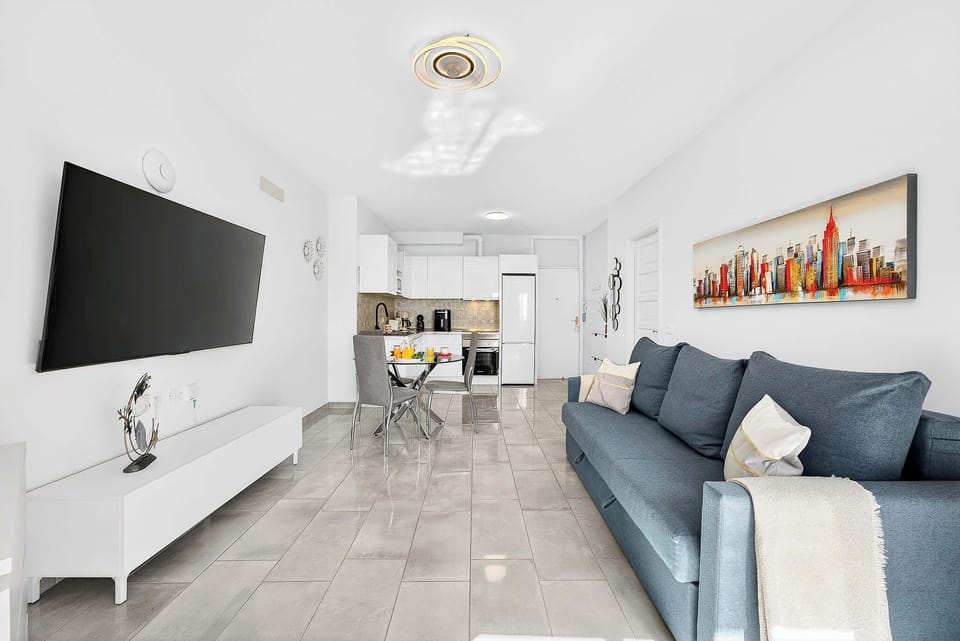 Livingroom with Dining Table, Sofa Bed, Flatscreen TV, and Balcony View