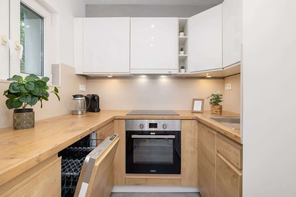 Fully equipped kitchen with oven, fridge, dishwasher, electric kettle and coffee machine.
