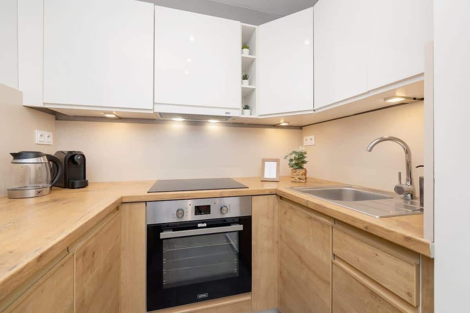 Fully equipped kitchen with oven, fridge, dishwasher, electric kettle and coffee machine.