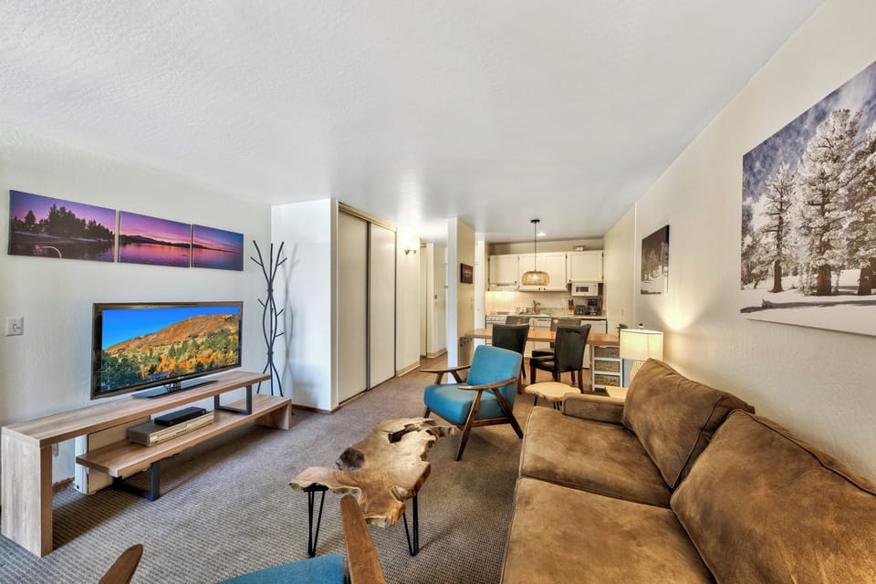 Relax in your stylish living space with plush seating, mountain artwork, and a full kitchen for preparing meals after your adventures.