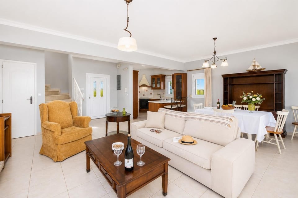 Open-plan living room with sofa, dining area, kitchen, ornamental fireplace, A/C, WiFi internet, and satellite TV
