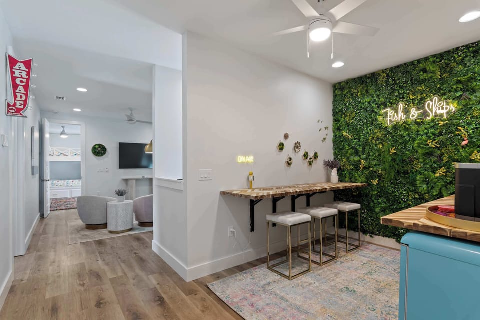 Open kitchen nook w/ bar seating, greenery accents & an easy social flow