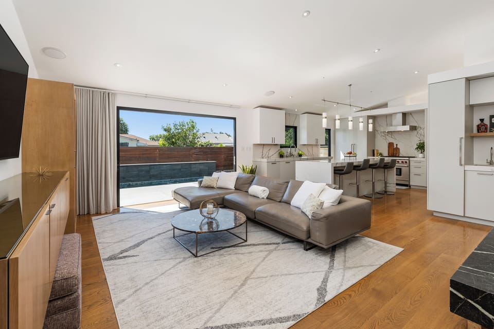 Open concept living room and kitchen with sleek cabinetry and a central island.
