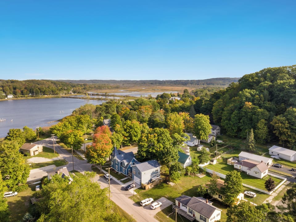 OVERVIEW:  Aerial view of the home with Betsie Bay, the Betsie River, and the dunes of Elberta in the background.
