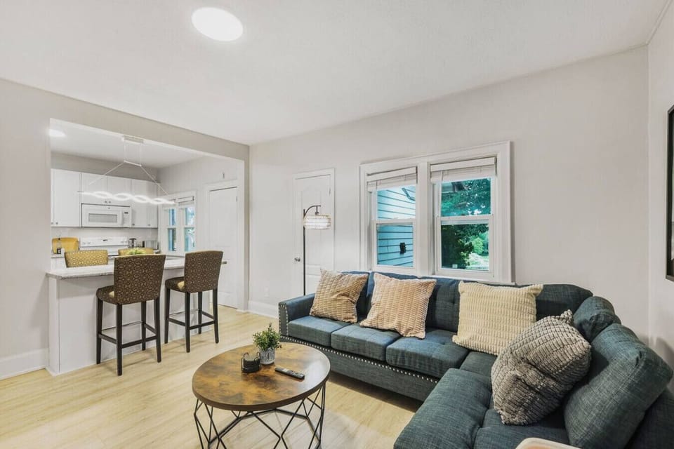 Bright and inviting, this open living space features a comfy sectional and a breakfast bar that connects to the kitchen. The perfect spot to gather, share meals, or simply unwind with plenty of natural light.
