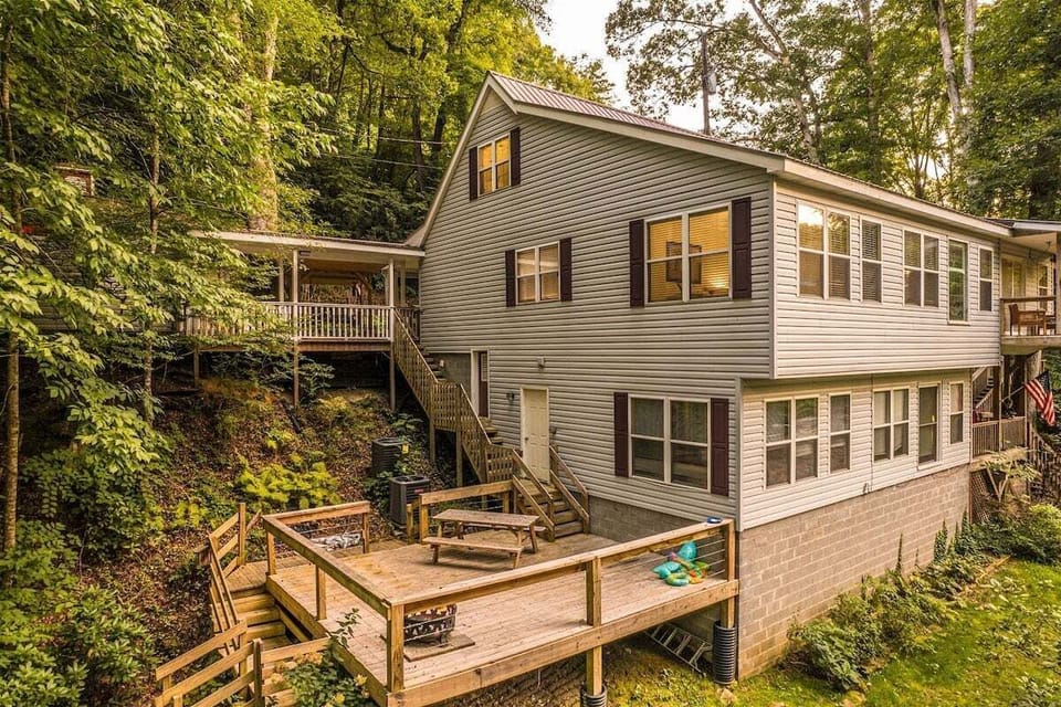 Exterior view of the multi-level cabin with wraparound decks and wooded mountain setting at Alarka Creek Oasis in Bryson City, North Carolina.