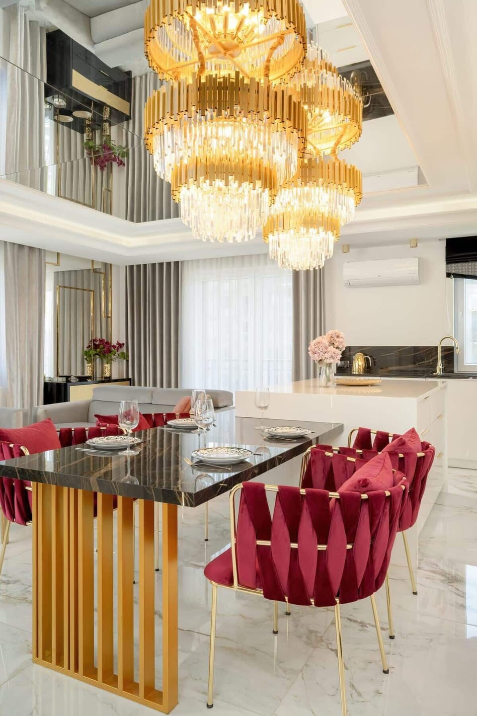 Another view of the elegant dining table above which hangs a gold chandelier.