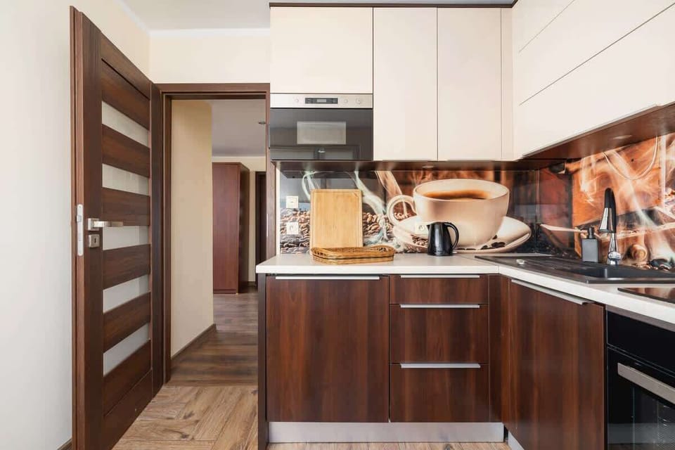 Warm-toned kitchen with wooden countertops and upper cabinets.