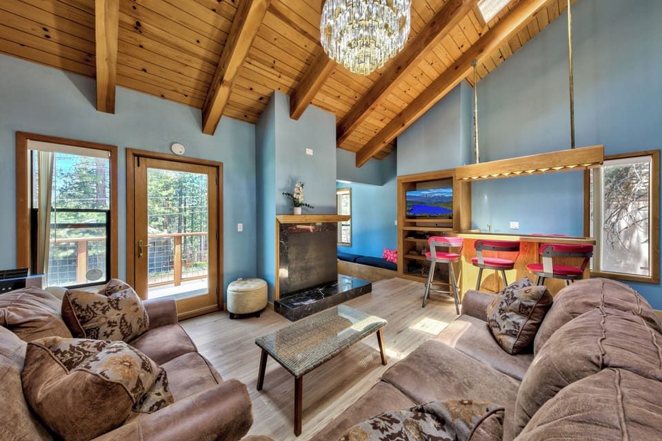 Sink into plush sofas beneath soaring wood beams. Your mountain retreat awaits with stunning vaulted ceilings and warm natural light.