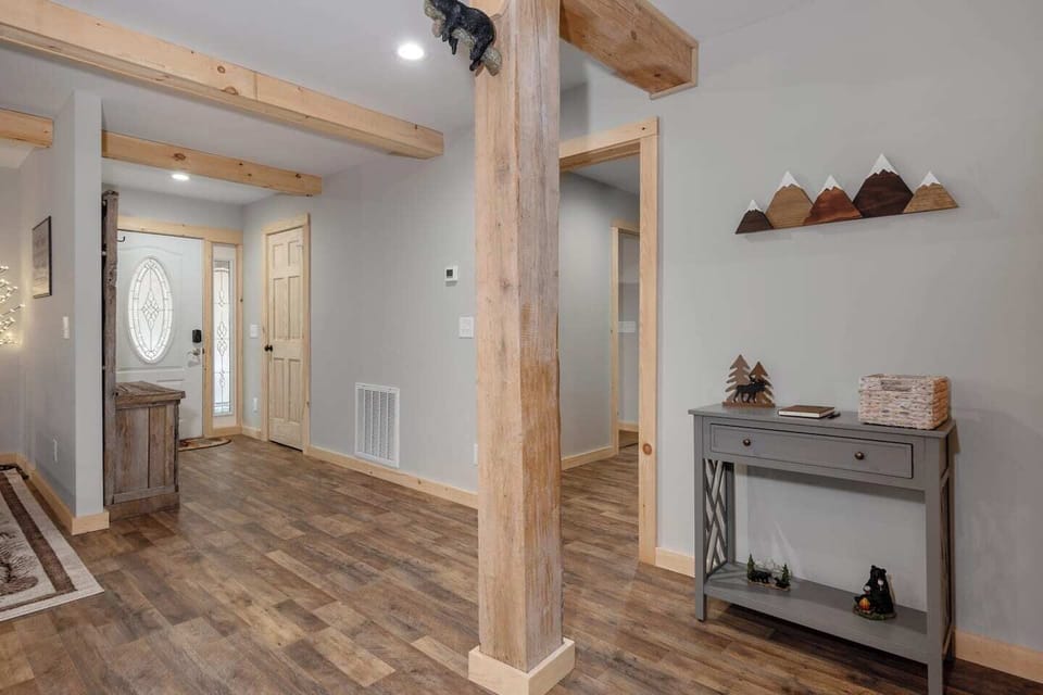 First impressions matter!  This inviting entryway features wood beam accents, a rustic grey hall tree, and welcome table to set the tone for your stay.  Located behind the wood door is a half bathroom.  Just off the front entryway, there is a discree