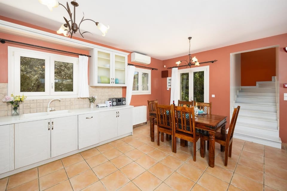 Open-plan living room with sofas, dining area, kitchen, ornamental fireplace, A/C, WiFi internet, and satellite TV